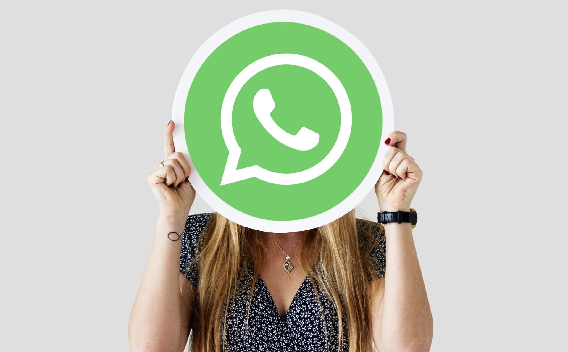 Mulher segurando o ícone gigante do WhatsApp GB Pro, vale a pena baixar?