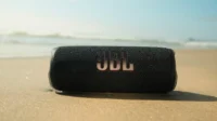 JBL Flip 6 sendo usada na areia da praia