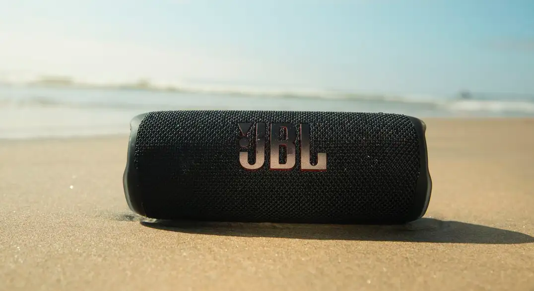 JBL Flip 6 sendo usada na areia da praia